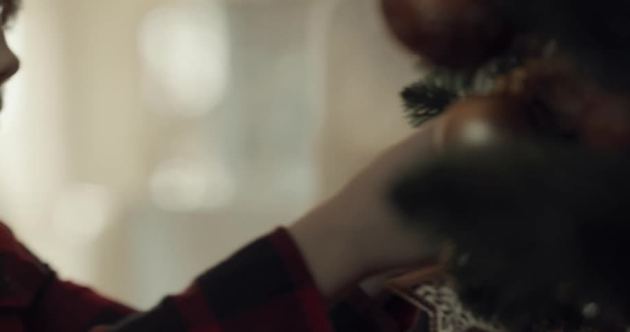 A boy helps to decorate a christmas tree