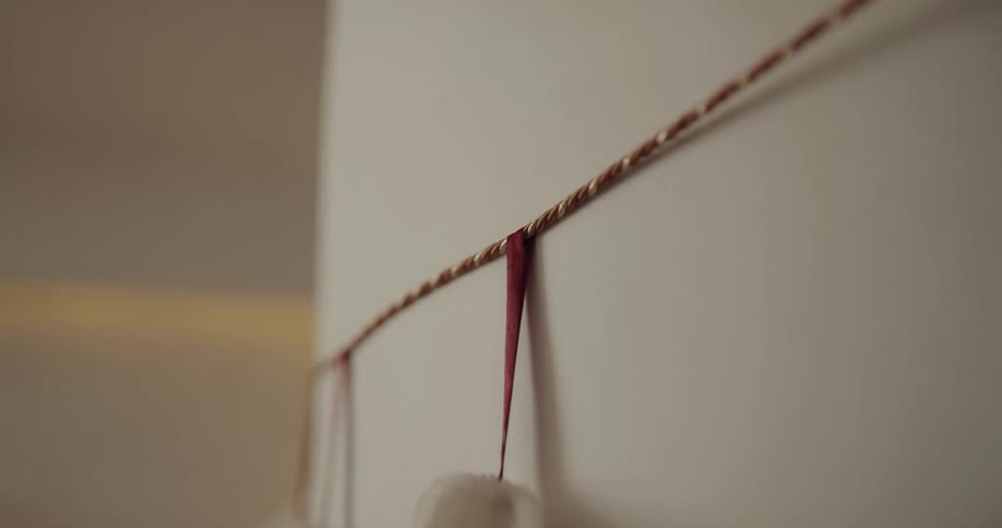 A young boy hangs a christmas stocking on a piece of string on the wall