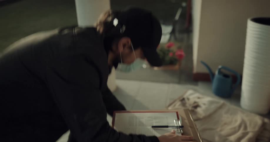 A package courier knocks on the door of a house before leaving a stack of packages on the porch