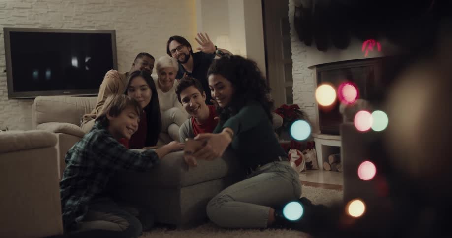A group of friends sit around a couch and take a selfie together
