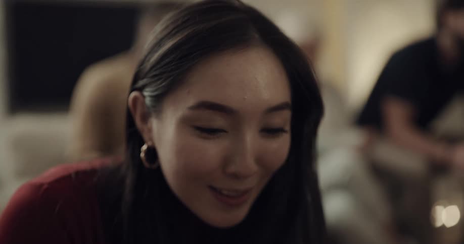 A woman smiles as she opens a gift