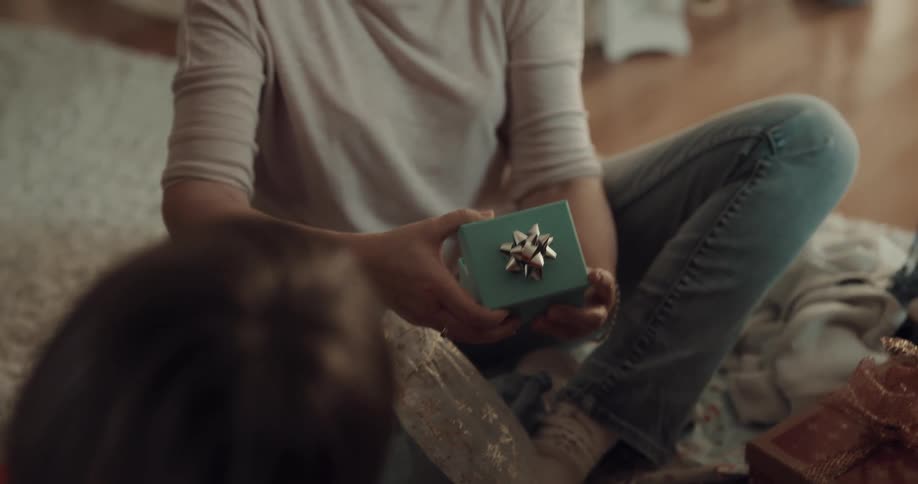 A family exchange gifts then hug