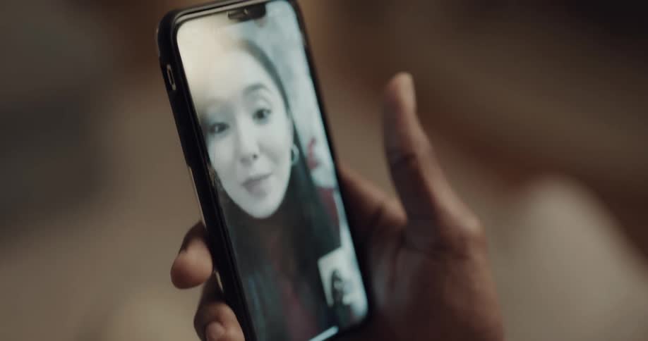 A man uses a smartphone to video chat with woman