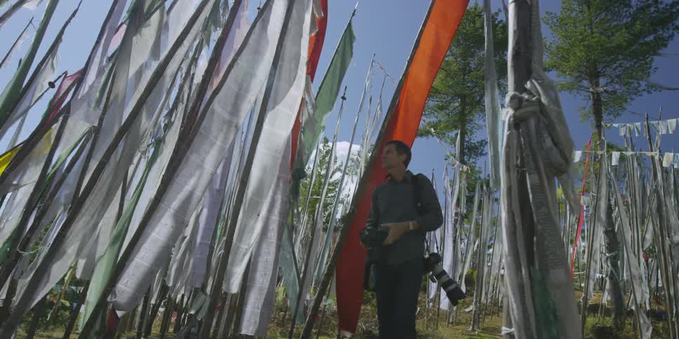 A photographer walks through fabric banners outside