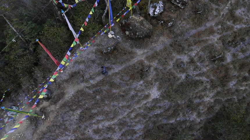 Aerial view of a person walking downhill under some flags