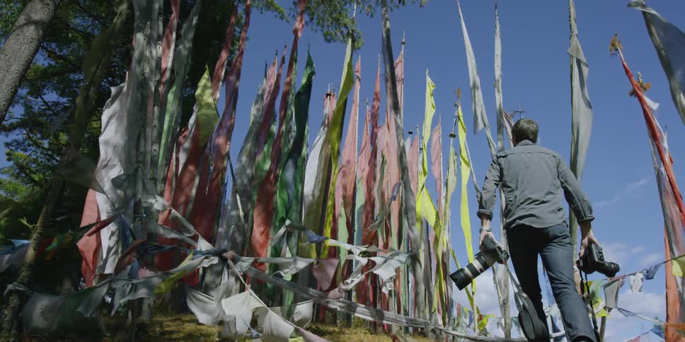 A man is walking past a bunch of flags
