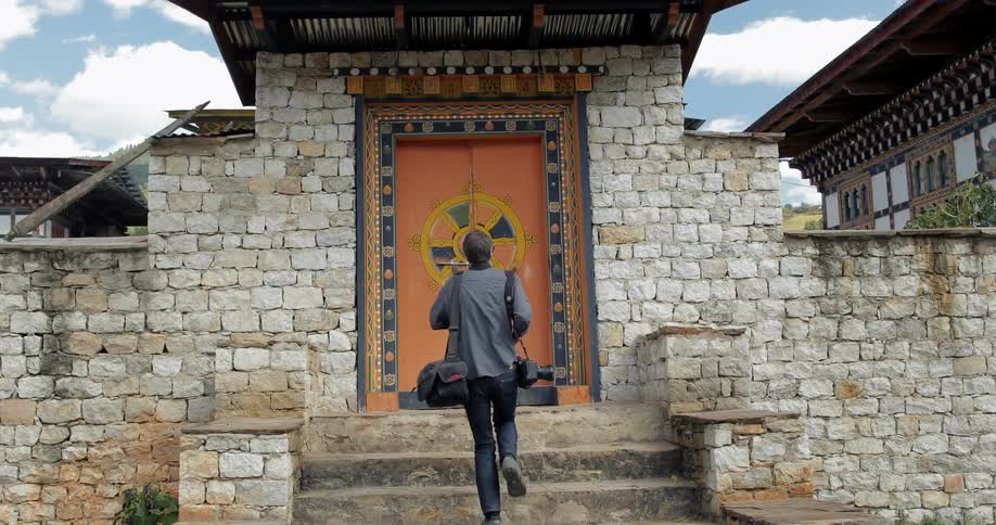 A photographer enters a gated building
