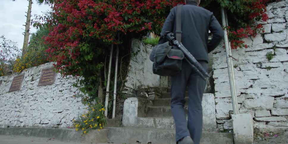 A photographer approaches a walled-in building