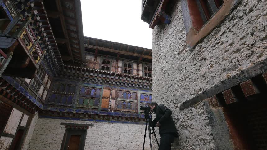 A man is taking some photographs of a building