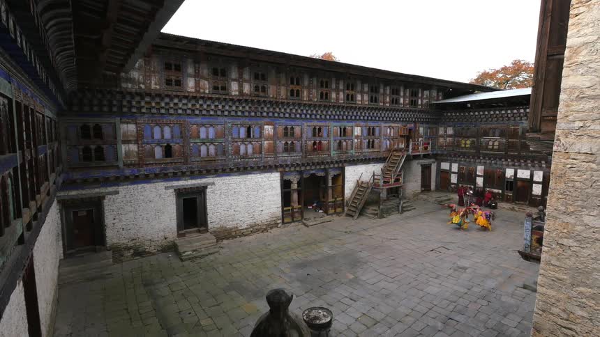 Dancers in traditional costume perform in an old courtyard
