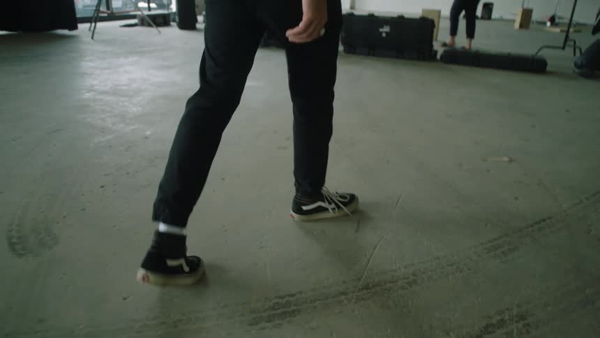 A man walks through a film studio with cement floors