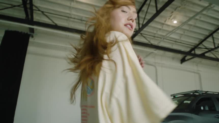 A young woman jogs inside a building and runs her hand through her hair