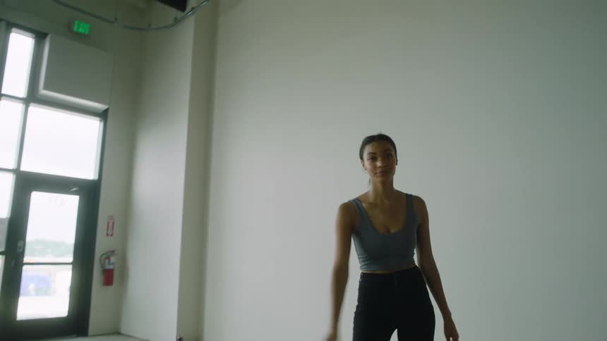A young woman looking around an empty warehouse