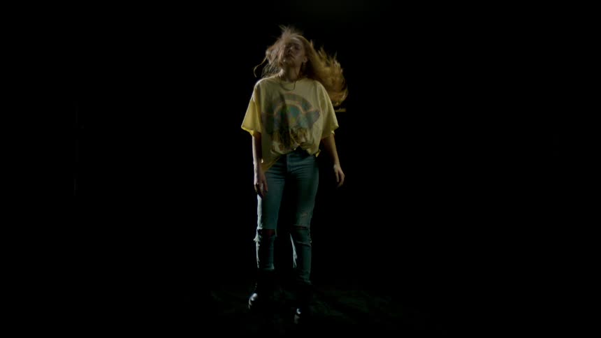 A young woman quickly rises from a bow causing her hair to flip over her head and come resting behind her