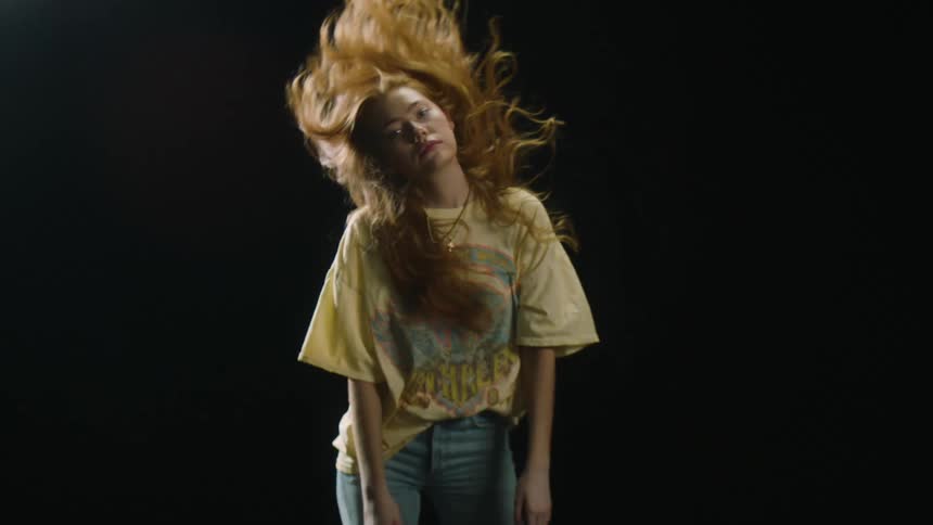 A girl flips her hair while facing the camera