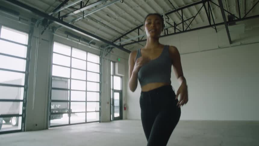 A black female jogging inside a building