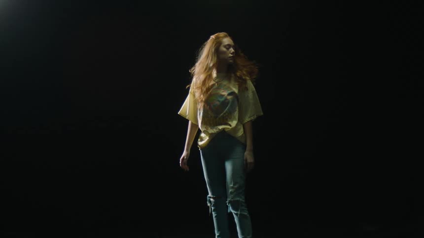 A woman is standing in a dark room