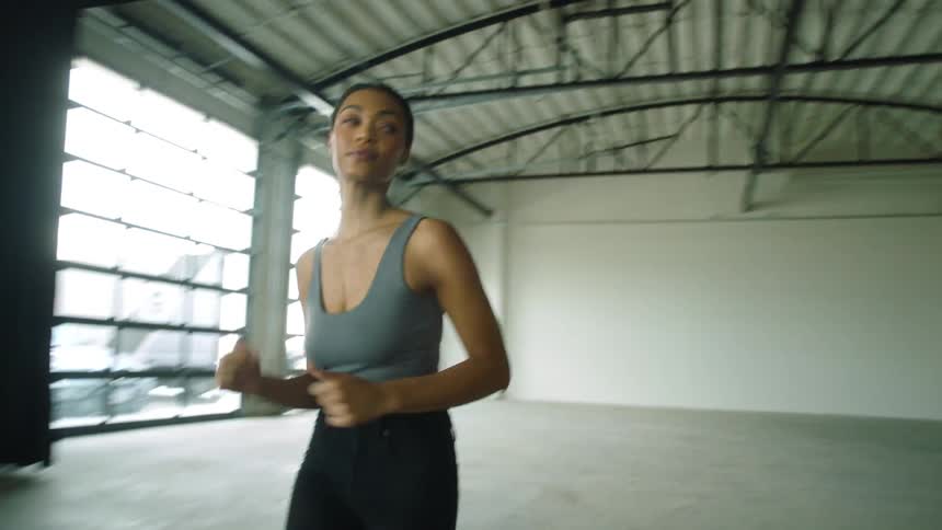 A woman is jogging in an empty room