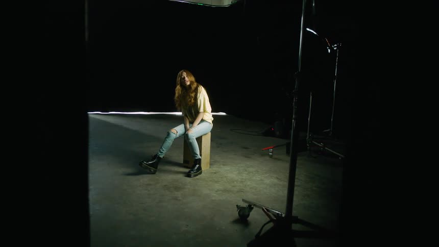 A woman sitting on a box in a room
