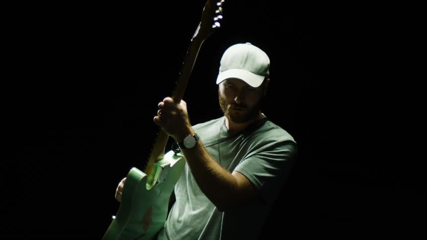 Man playing the guitar possibly for a photo shoot
