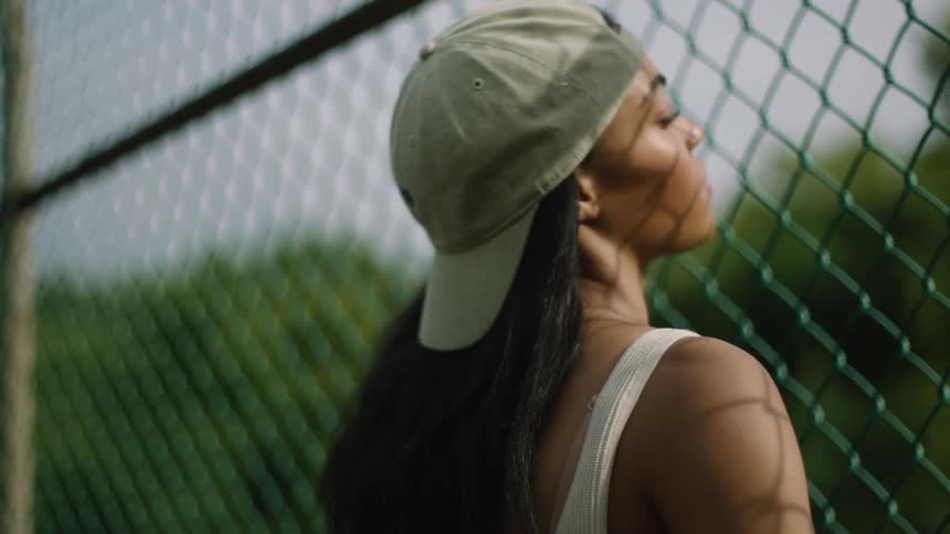 A woman is standing by a fence in spring
