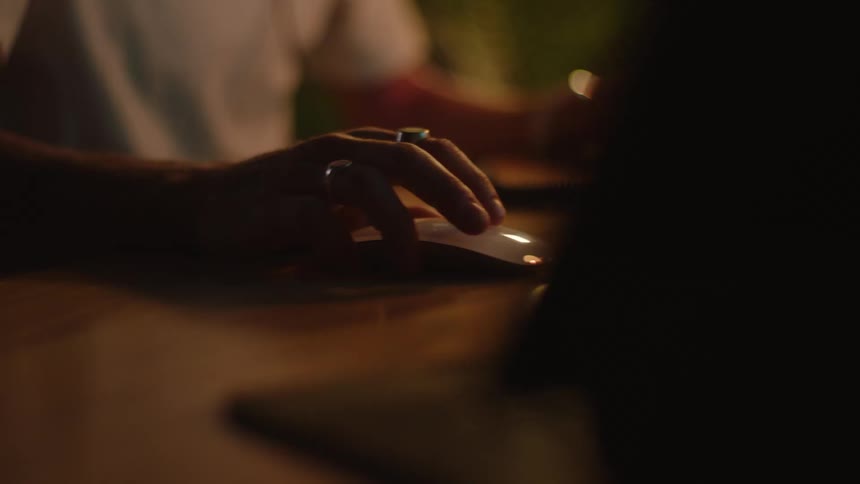 A person sitting at a table with a mouse and keyboard