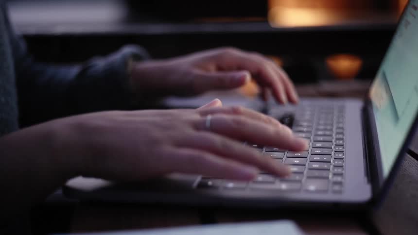 A person types quickly on a laptop