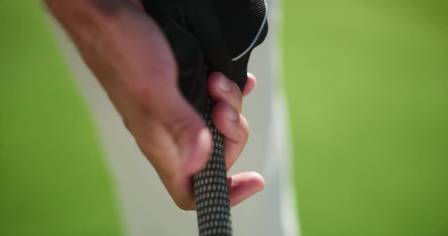 A golfer grips a golf club on a golf course