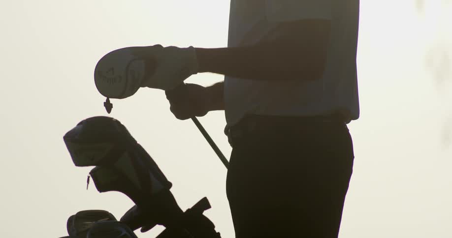 Golfer pulling out a club from golf bag