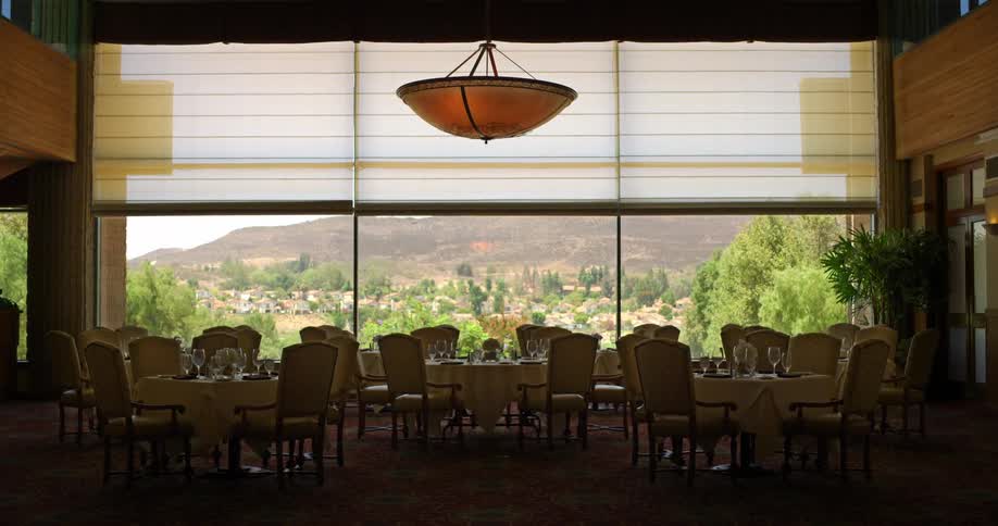 Tables and chairs in front of a large window in a restaurant