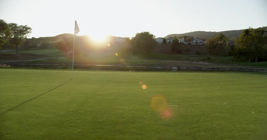 The sun is rising on the golf course