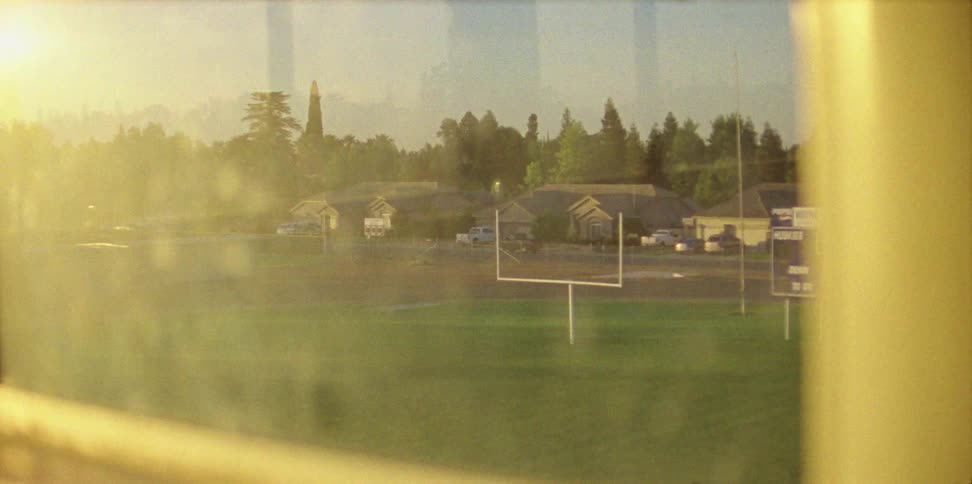 The sun shines on a football field with field goal posts