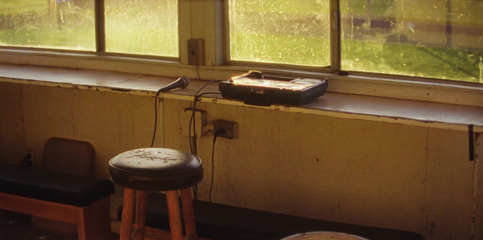A microphone lies on the counter in a sports press box