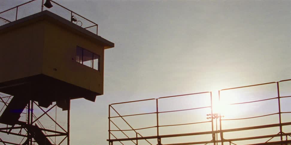Small town athletics stadium with sun the sky and clouds in the background
