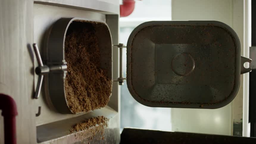 Dirt falls out of a large machine in a factory