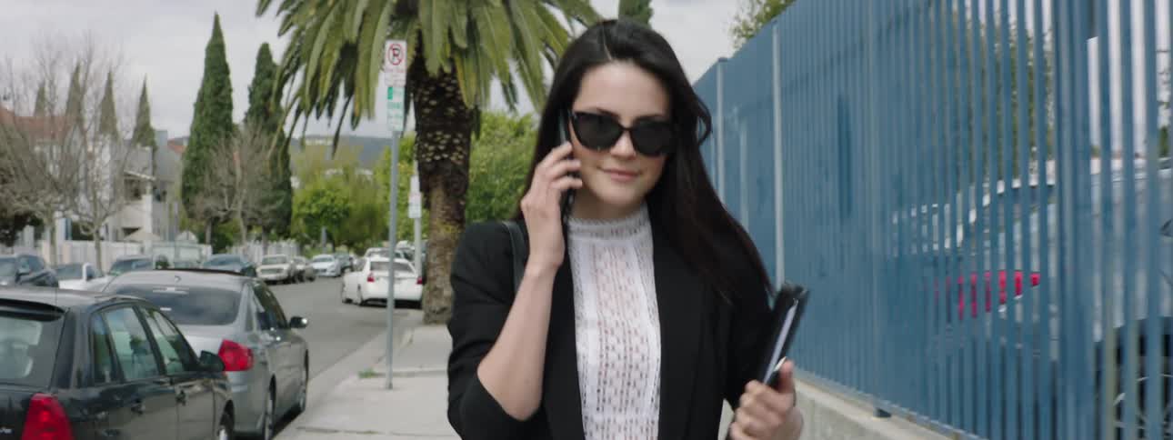 A woman talking on her cell phone as she walks down a city street