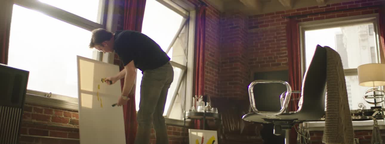 A man is painting near the window