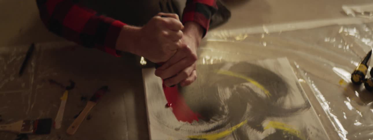 The artist squirts paint on his painting