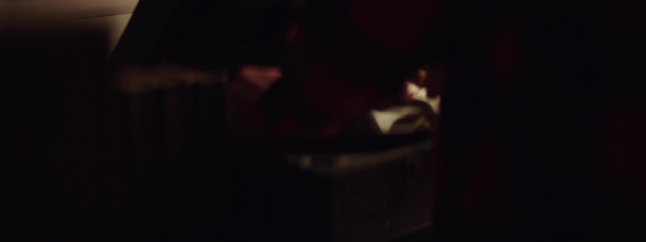 A person in a red sweater playing a record on a record player