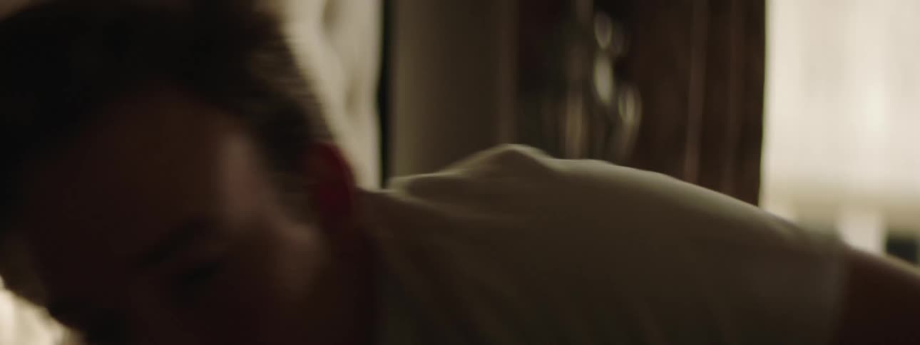 A man laying on a bed in a bedroom with a window in the background