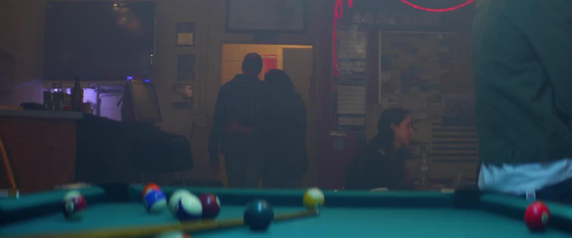 Couple walks out of a bar while holding each other