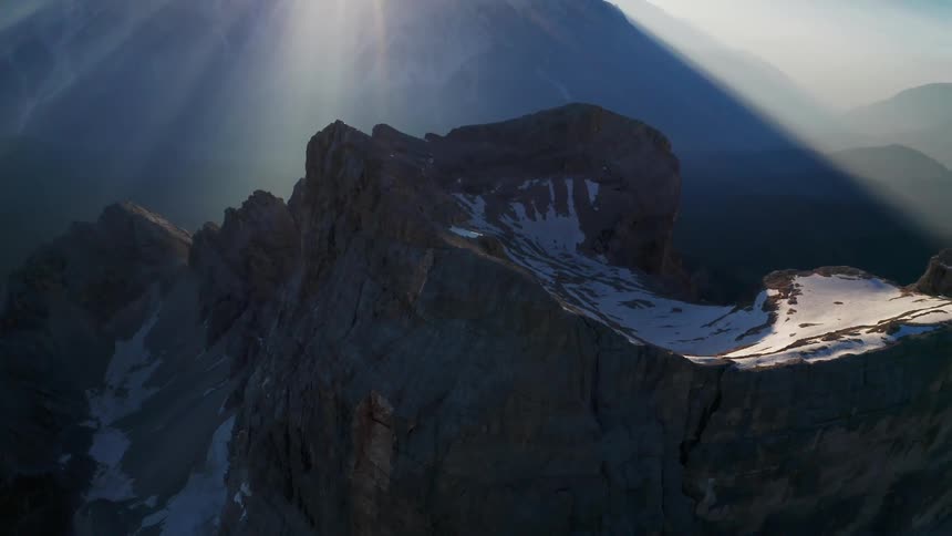 An aerial view of snowy mountain peaks on a sunny winter day