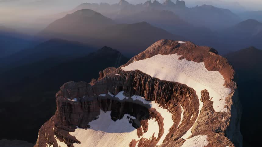 A snowy mountain landscape at sunset