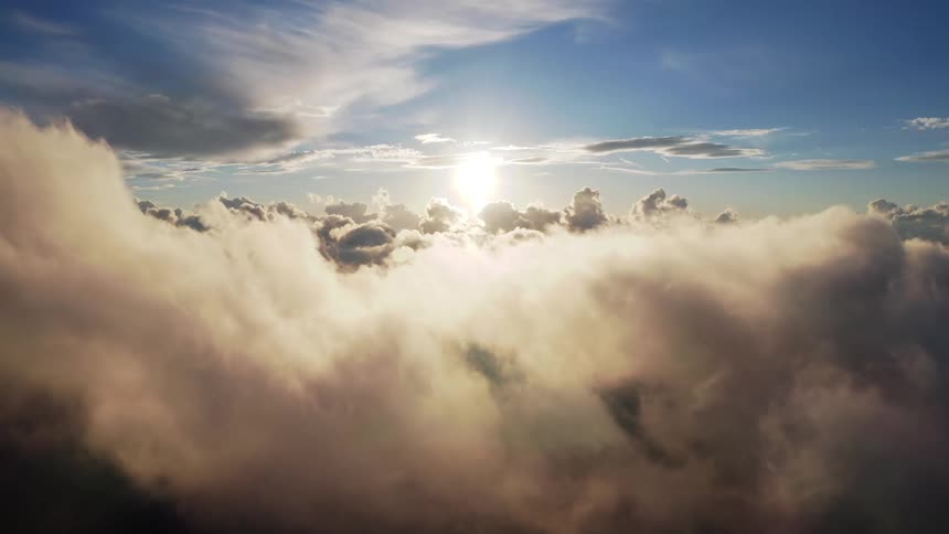Sunlight filters through the layer of clouds floating on a blue sky