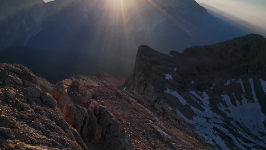 Sunlight shines down on a foggy mountain range