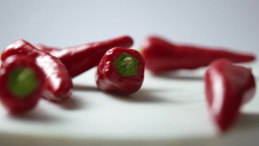 Red peppers falling onto a spinning white platter