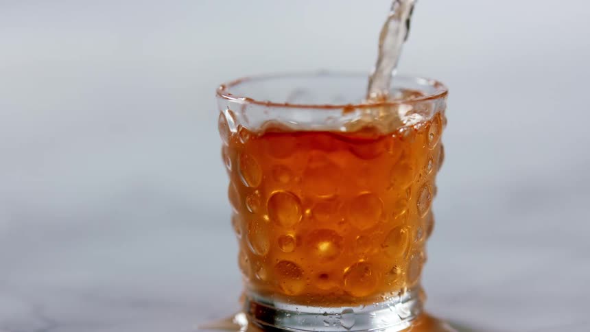 A drink being poured in to a glass