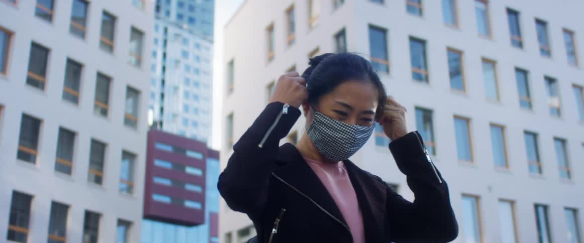 A woman is standing outdoors in the city