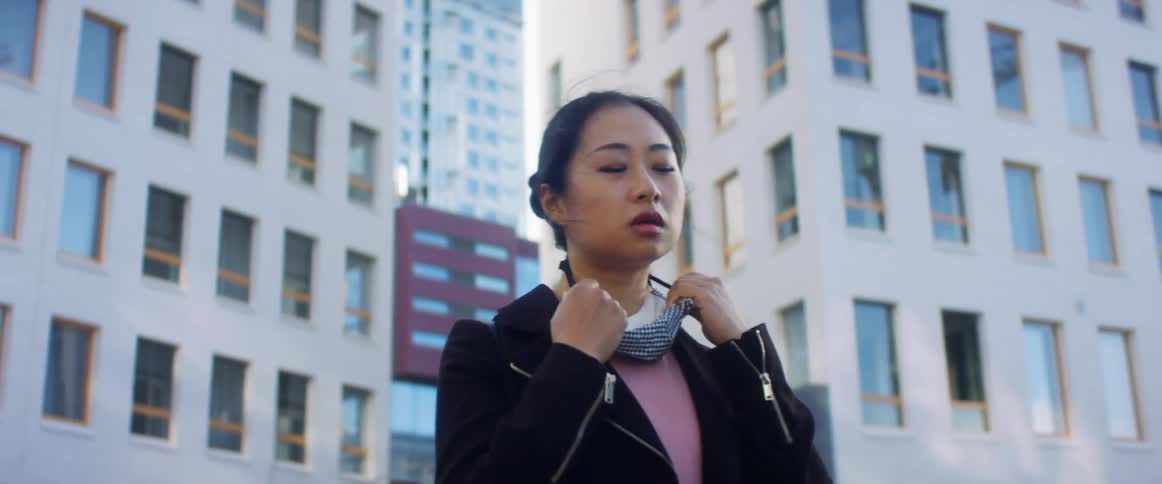 A woman is standing outdoors in the city