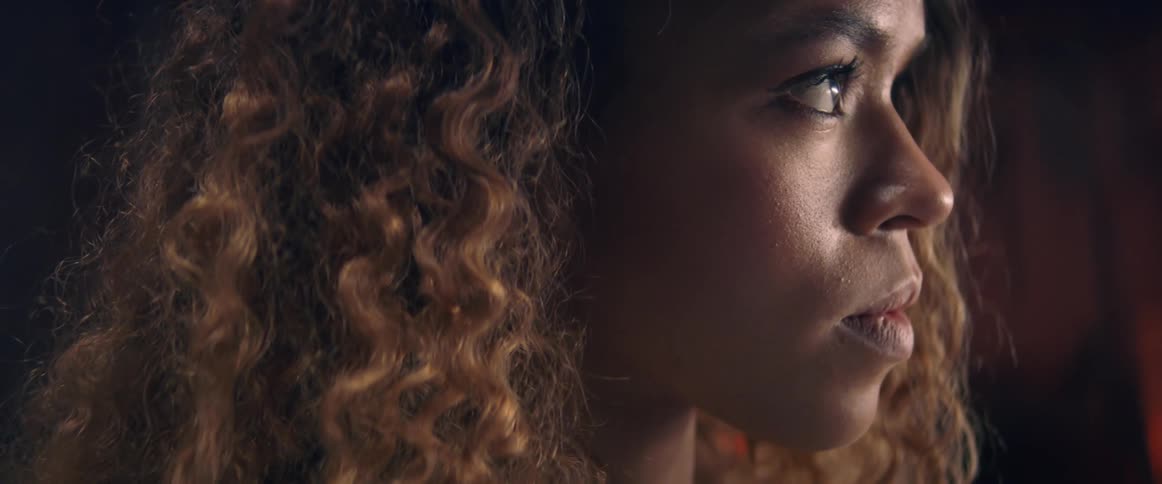 Side view of a black woman with brown curly hair